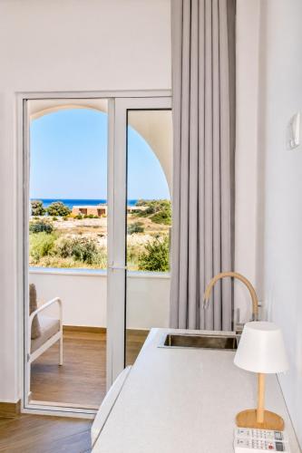 a bedroom with a view of the ocean at Ela Mare Sea View Apartments in Malia