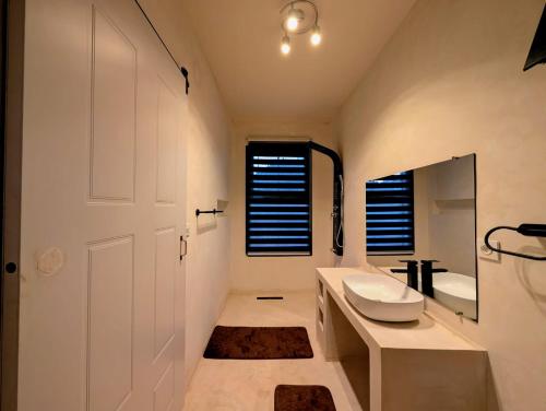 a white bathroom with a sink and a mirror at Riva guest house in Antananarivo