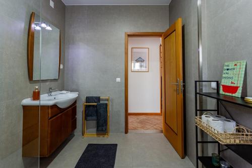 a bathroom with a sink and a mirror at Alegria Beach House in Vila do Conde