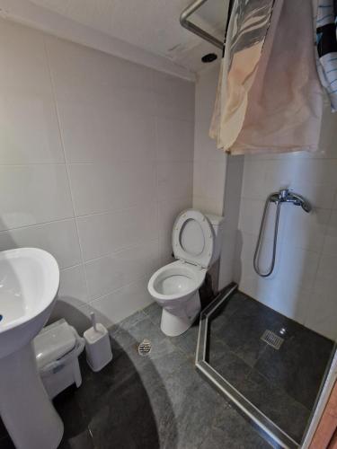a bathroom with a toilet and a sink at Cozy apartment with a great view! R in Metamorfosi