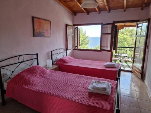 two beds in a room with a view of the ocean at Cozy apartment with a great view! R in Metamorfosi