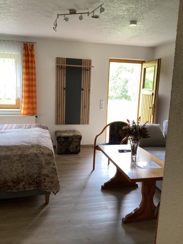 a bedroom with a bed and a table in a room at Apartment far away from Africa in Steinach