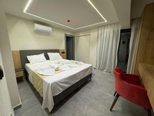 a hotel room with a bed and a red chair at Lumy Suite Hotel Bodrum Gumbet - Private Pool in Bodrum City