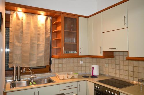 a kitchen with white cabinets and a sink at D6 Lake View in Kastoria