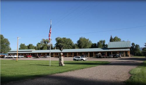 a car parked in front of a building with an american flag at Chama River Bend Lodge in Chama