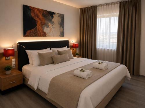 a bedroom with a large bed with two towels on it at M14 Stay Cluj in Cluj-Napoca