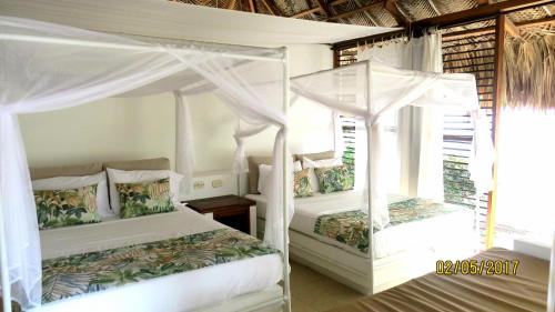 2 camas en un dormitorio con paredes blancas en Hukumeizi Hotel en Palomino