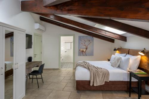 a bedroom with a bed and a desk in a room at Briaa Wellness Resort Hotel Gilboa - Adults Only in Maalé-Hagilbo‘a