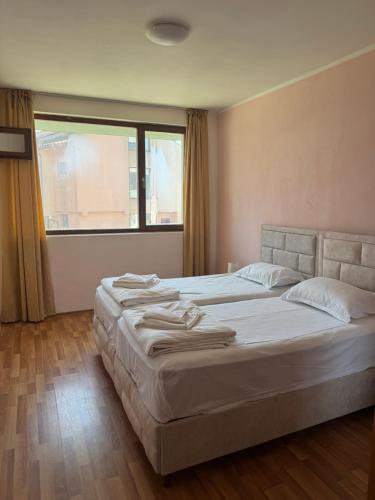 a bedroom with two beds and a large window at Dream Bay Apartments in Tsarevo
