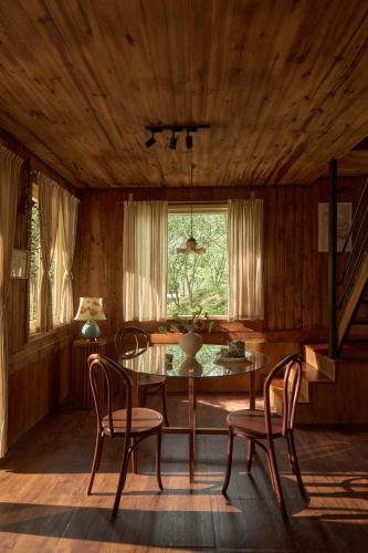 a dining room with a table and chairs and a window at Dreaming Retreat Da Lat in Ấp An Kroët