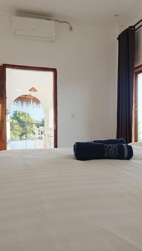 a bed with a blue pillow on top of it at USTIN Villas Lombok in Bumbang