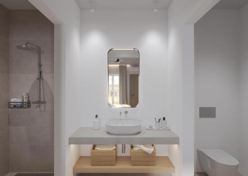 a bathroom with a sink and a mirror at Vilos Luxury Suites in Pollonia