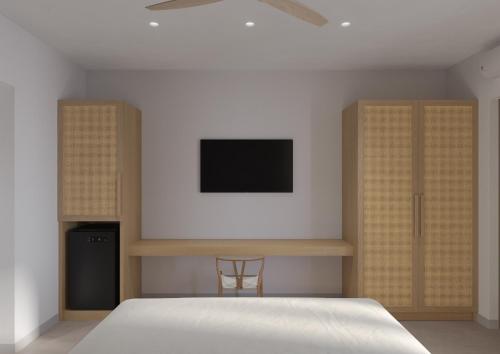 a bedroom with a bed and a tv on the wall at Vilos Luxury Suites in Pollonia