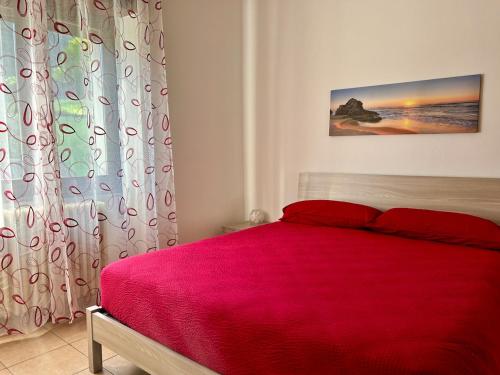 a bedroom with a bed with a red blanket at La Farfalla B&B - Mark&Rosy in Malonno