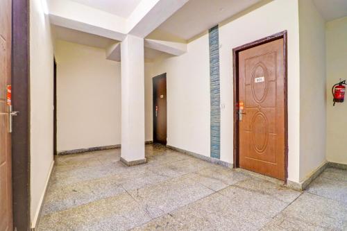 a hallway with a wooden door in a building at Hotel O Honey Inn in New Delhi