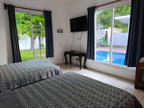 a bedroom with a bed and a view of a pool at Chinelos Ixtapa in Ixtapa
