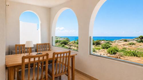 a dining room with arched windows and a table and chairs at Ela Mare Sea View Apartments in Malia