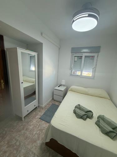 a small bedroom with a bed and a mirror at torremolinos centro parking privado in Torremolinos