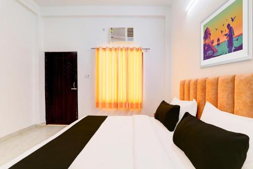 a bedroom with a white bed and a yellow curtain at Hotel O Samar palace in Lucknow