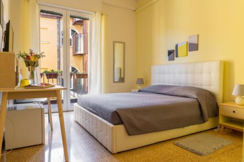 a bedroom with a bed and a desk and a window at San Felice Central Room in Bologna