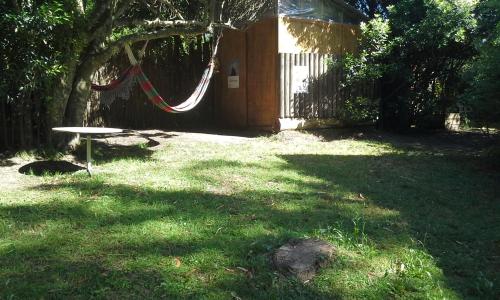 a backyard with a hammock in the grass at Posada IRSIS in La Pedrera