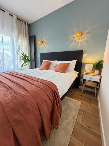 a bedroom with a bed and two lights on the wall at Suite indépendante proche Bordeaux in Rions