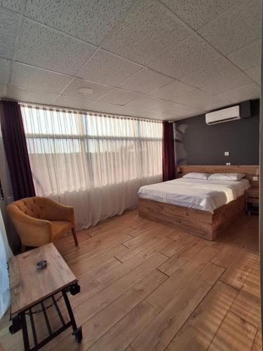 a bedroom with a bed and a chair and a table at Kasabalı OTEL&BUNGALOW in Bulgurca