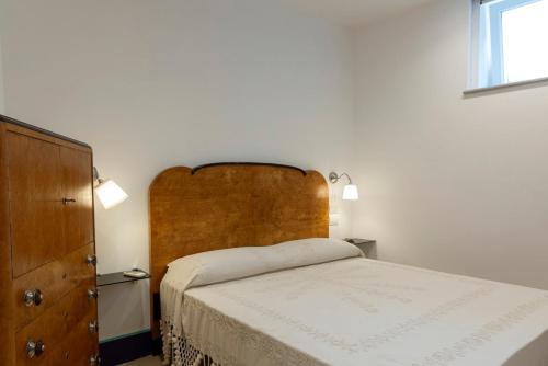a bedroom with a bed with a wooden headboard and a dresser at Circumpiso in Massa Lubrense