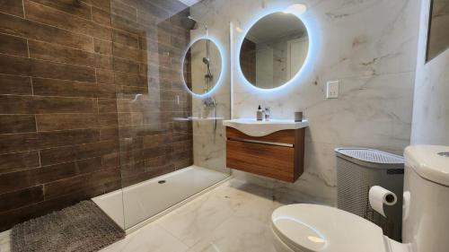 a bathroom with a tub and a sink and a toilet at Hal Wardija Resort Apartments in Qala