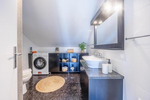 a bathroom with a sink and a washing machine at Paul Sun Scape - Seaside Ocean & Sunset View in Paul do Mar