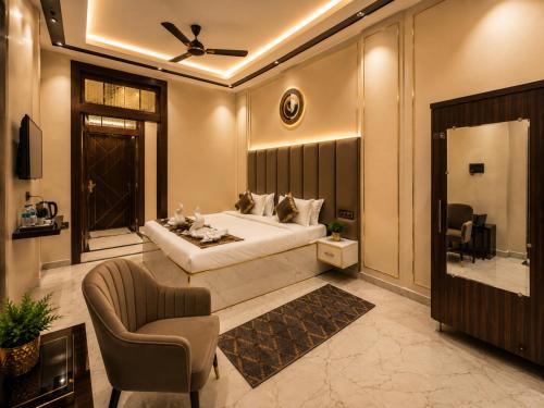 a bedroom with a king sized bed and a chair at Hotel Prabh Aasra Near Shree Ram Mandir in Ayodhya