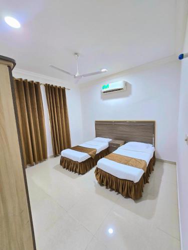 a hospital room with two beds and curtains at رحاب السعاده rehab alsaadah apartment in Salalah
