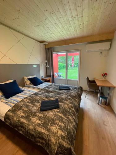 a bedroom with a large bed with a large window at Paatsalu Sadam in Paatsalu