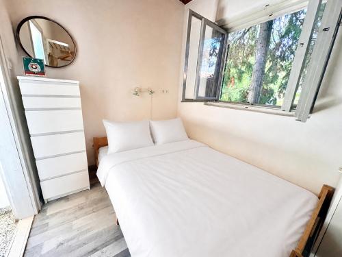 a small bedroom with a bed and a window at Nádaspart Vendégház in Zánka