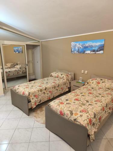a bedroom with two beds and a mirror at Cibali rooms in Catania