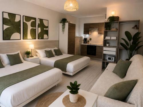 a hotel room with two beds and a couch at Hotel Cayrons Vence & St Paul de Vence in Vence