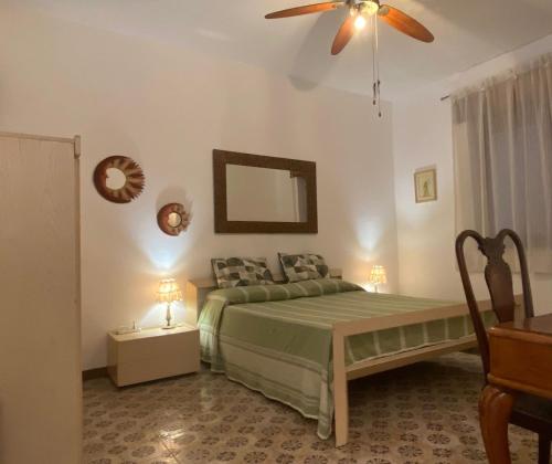 a bedroom with a green bed and a ceiling fan at Happy Rock in Formia