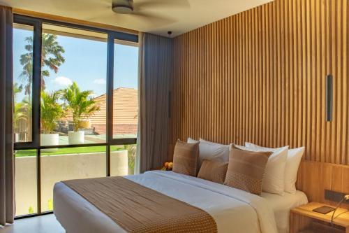 a bedroom with a large bed and a large window at Antonella De Rosa Villas in Nusa Dua