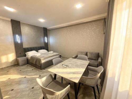 a room with a bed and a table and chairs at River Light-Guest House in Alaverdi