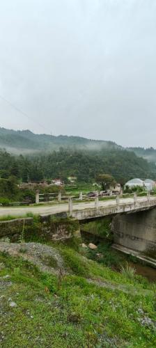a bridge over a river with a mountain in the background at Fursat Exclusive Solitude in Rāmgarh