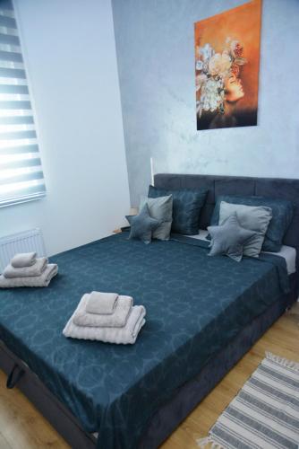 a large blue bed with towels on top of it at Lake&Chill Residence in Palić