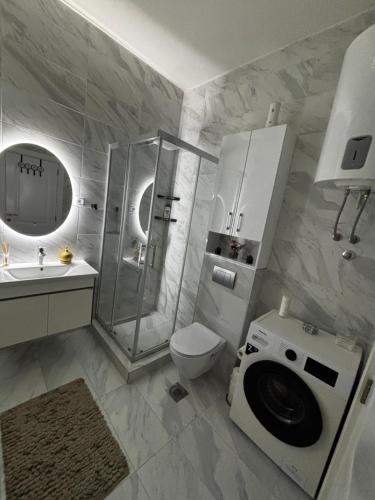 a bathroom with a shower and a toilet and a sink at Lake&Chill Residence in Palić