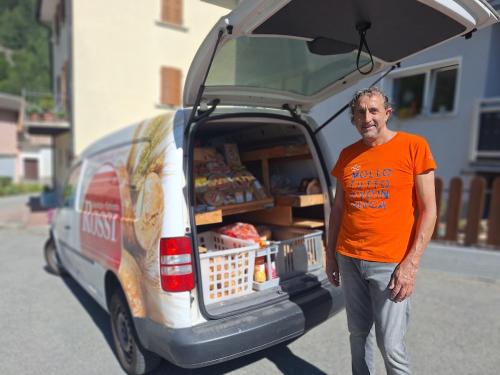 a man standing in the back of a van with its door open at Casa Piazzo in Brusio