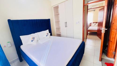 a bedroom with a blue bed with two pillows at 3 bedroom house buxton in Mombasa
