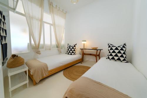 a bedroom with two beds and a window at Sardina Ocean Front Apartment in Gáldar
