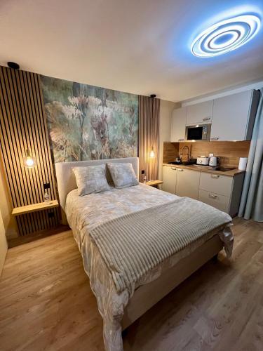 a bedroom with a bed with a painting on the wall at L'Escale d'Armorique 2 in Languidic