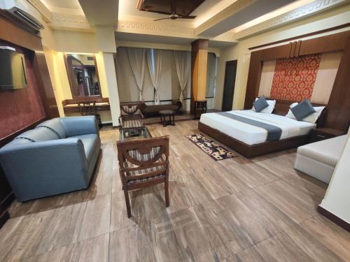 a hotel room with a bed and a couch at Hotel Metro Regency Meerut in Meerut