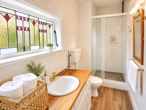 a bathroom with a sink and a toilet and a window at 21 Villa in Whangarei