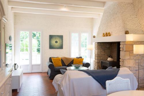 a living room with a couch and a fireplace at Moulin de Vigne in Corgnac-sur-lʼIsle