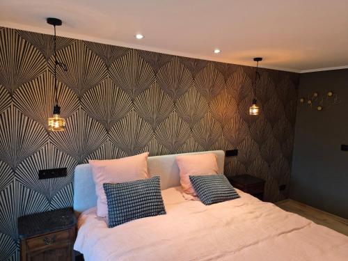 a bedroom with a large bed with two pillows at Le Petit Marcheloup in Paliseul